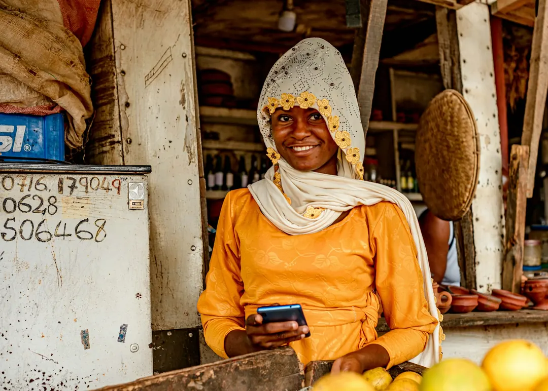 Une commerçante sur son étal consulte son téléphone